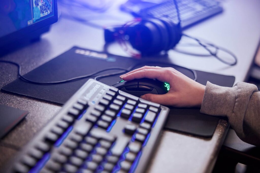 Hånd på gaming-mus og oplyst tastatur – professionelt setup til CS2-undervisning