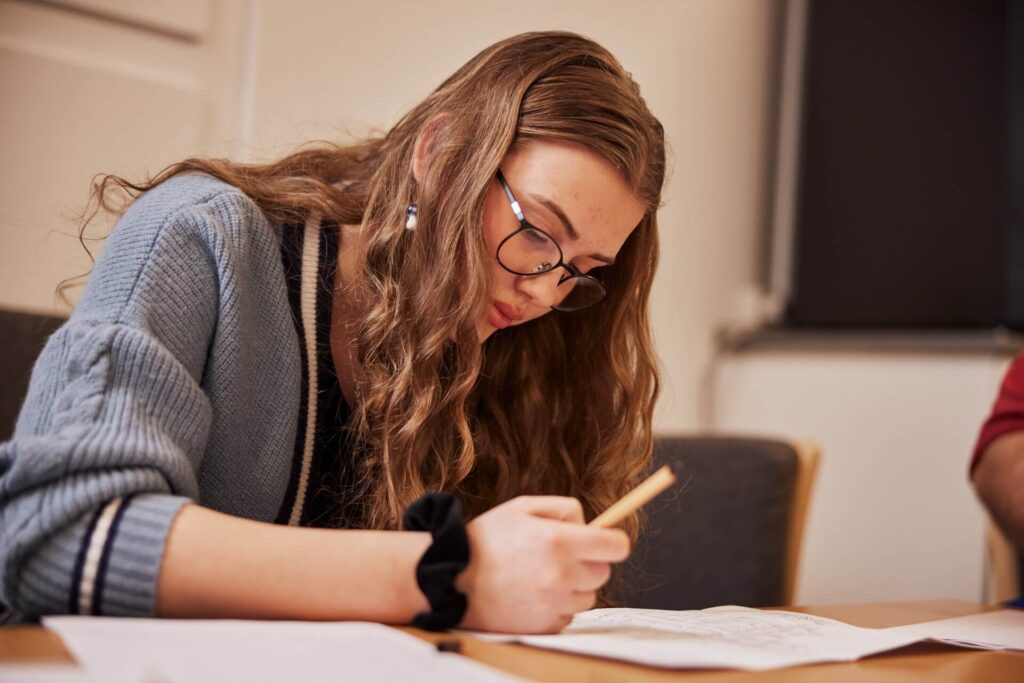 Fokuseret elev arbejder med opgaver – faglig fordybelse og støtte på en ordblind efterskole
