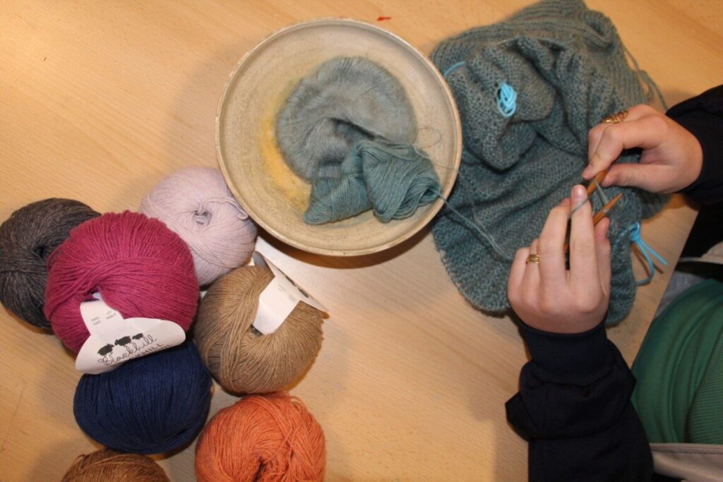 Strik og tekstil på efterskolen – elev strikker med uldgarn og lærer nye teknikker