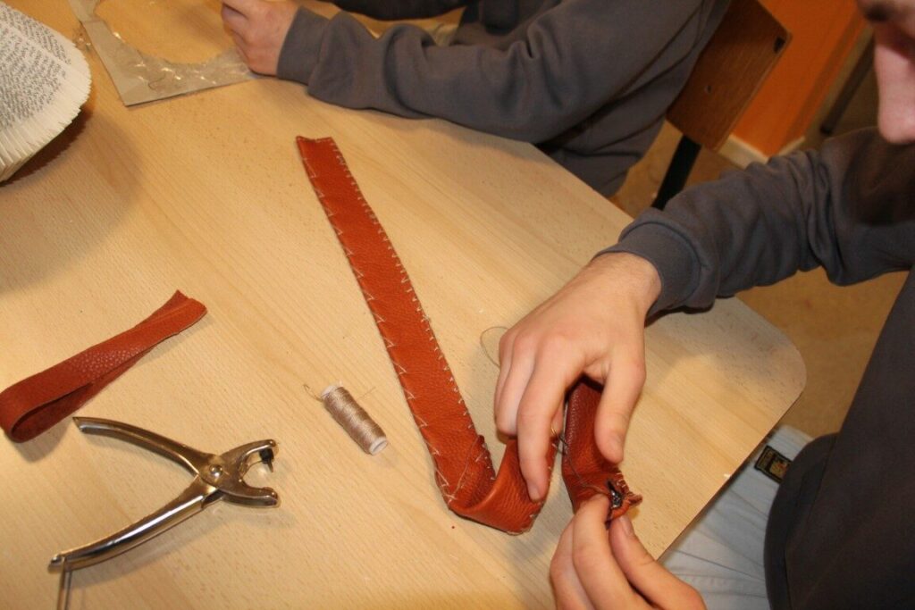 Elev arbejder med læder og design i det kreative værksted – håndværk og teknik på krea-linjen