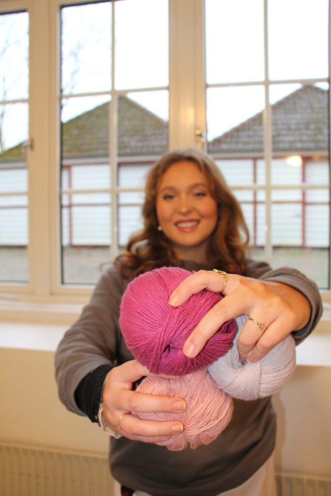 Smilende elev med farverigt garn – kreativitet, fordybelse og hyggeligt samvær i krea-faget